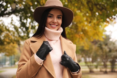 Photo of Young woman wearing stylish clothes in autumn park