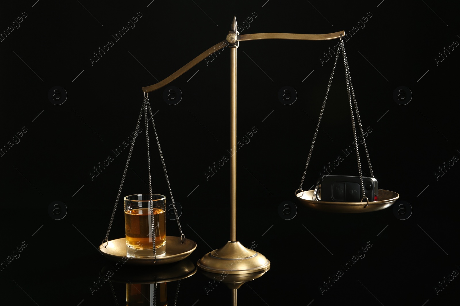 Photo of Scales of justice with alcohol and car key on black background. Drunk driving