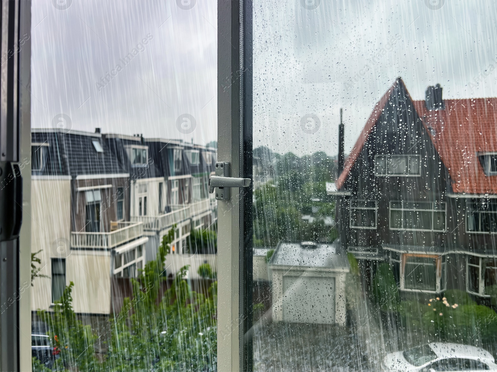 Image of Beautiful cityscape with buildings on rainy day, view through open window