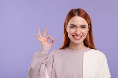 Photo of Beautiful woman with clean teeth showing ok gesture on violet background, space for text