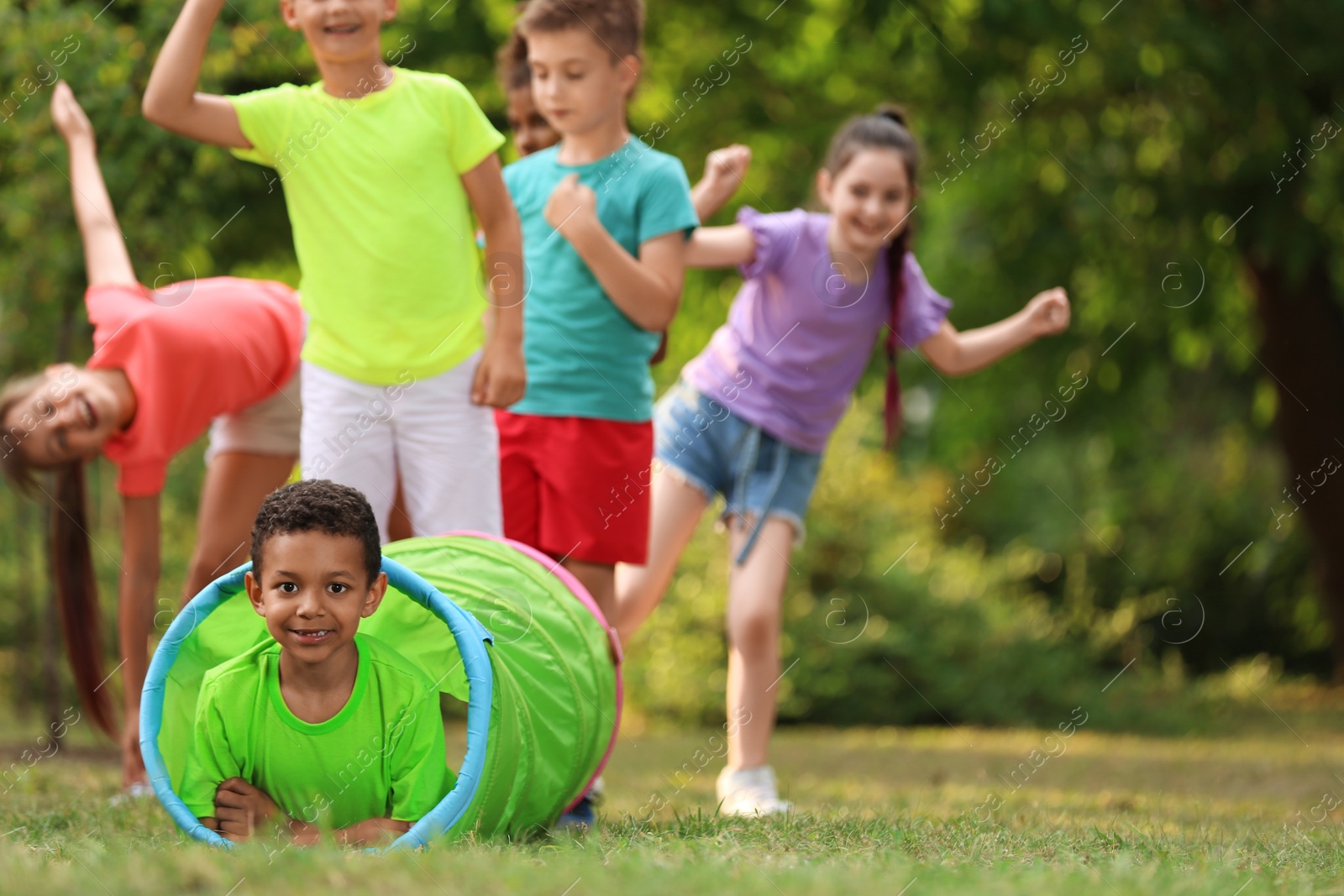 Photo of Cute little African-American child playing with friends in park, space for text