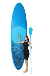 Happy woman with blue SUP board and paddle on white background