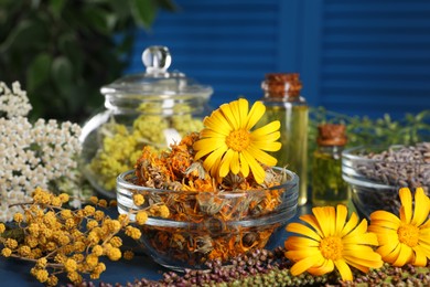 Photo of Bowl and many different herbs on blue table