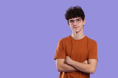 Photo of Portrait of teenage boy wearing glasses on violet background. Space for text