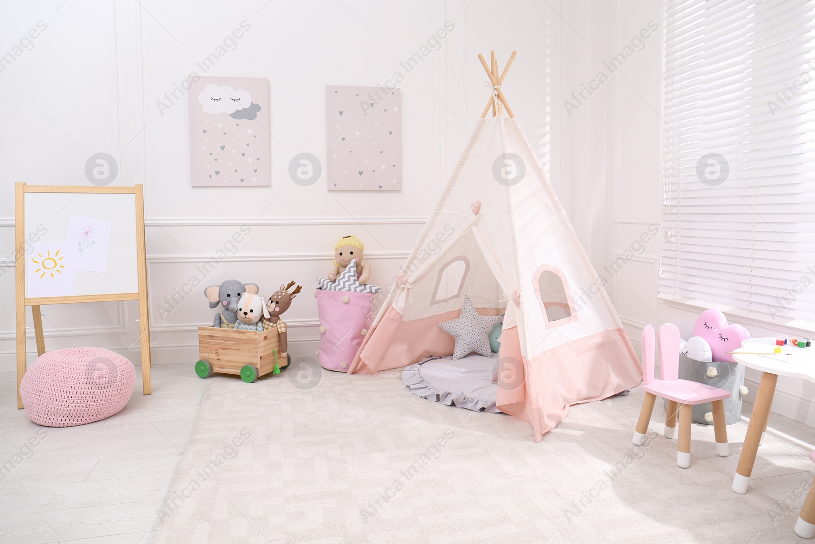 Photo of Cute child's room interior with toys, modern furniture and play tent