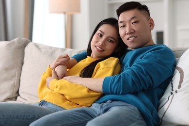 Photo of Happy young couple on sofa at home