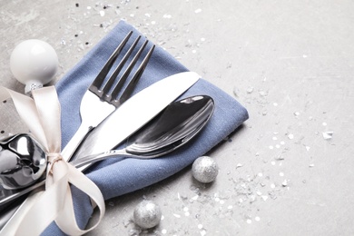 Cutlery set on grey table, space for text. Christmas celebration