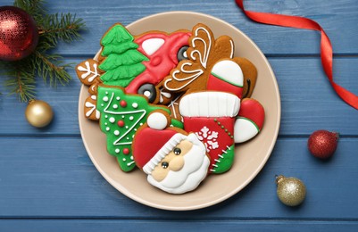 Different tasty Christmas cookies and decor on blue wooden table, flat lay