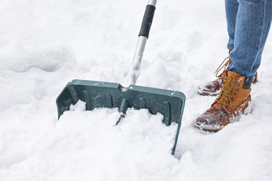 Man cleaning snow with shovel outdoors, closeup