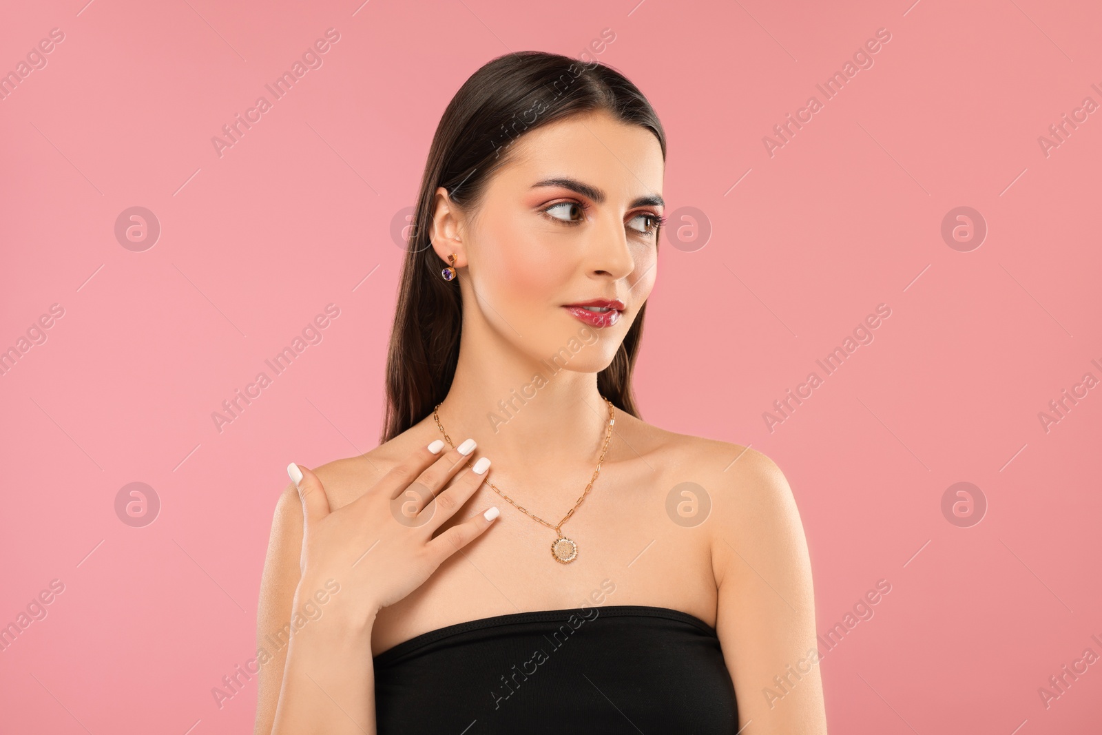 Photo of Beautiful woman with elegant jewelry on pink background