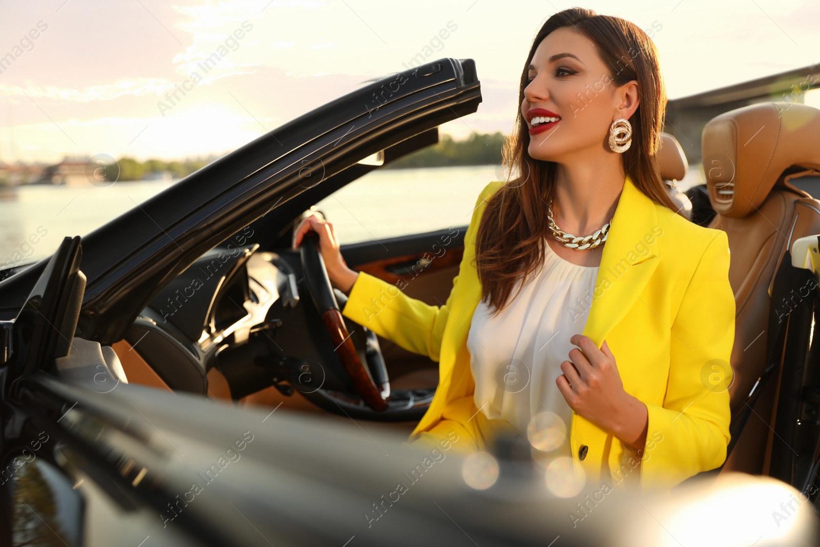 Photo of Beautiful businesswoman in luxury convertible car outdoors