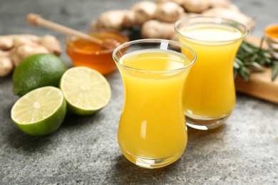 Photo of Immunity boosting drink and ingredients on grey table, closeup