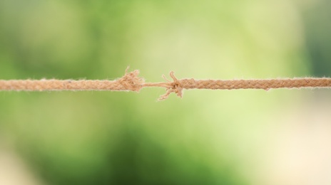 Frayed rope at breaking point against blurred background
