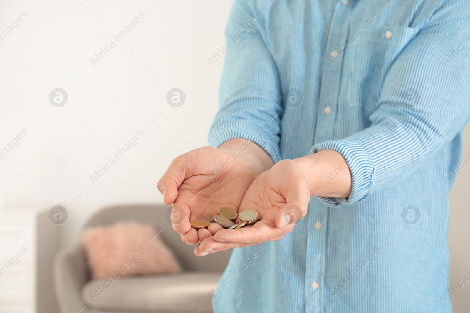 Photo of Man holding coins in hands indoors, closeup. Space for text