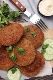 Tasty vegan cutlets served on wooden table, flat lay