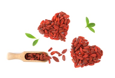 Composition with goji berries, scoop and leaves on white background, top view