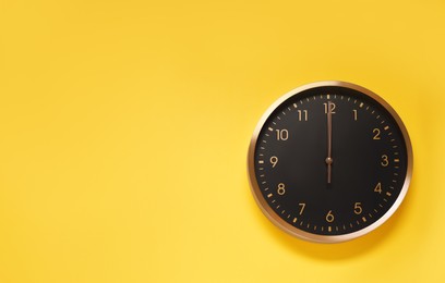 Stylish round clock on yellow background, top view with space for text. Interior element