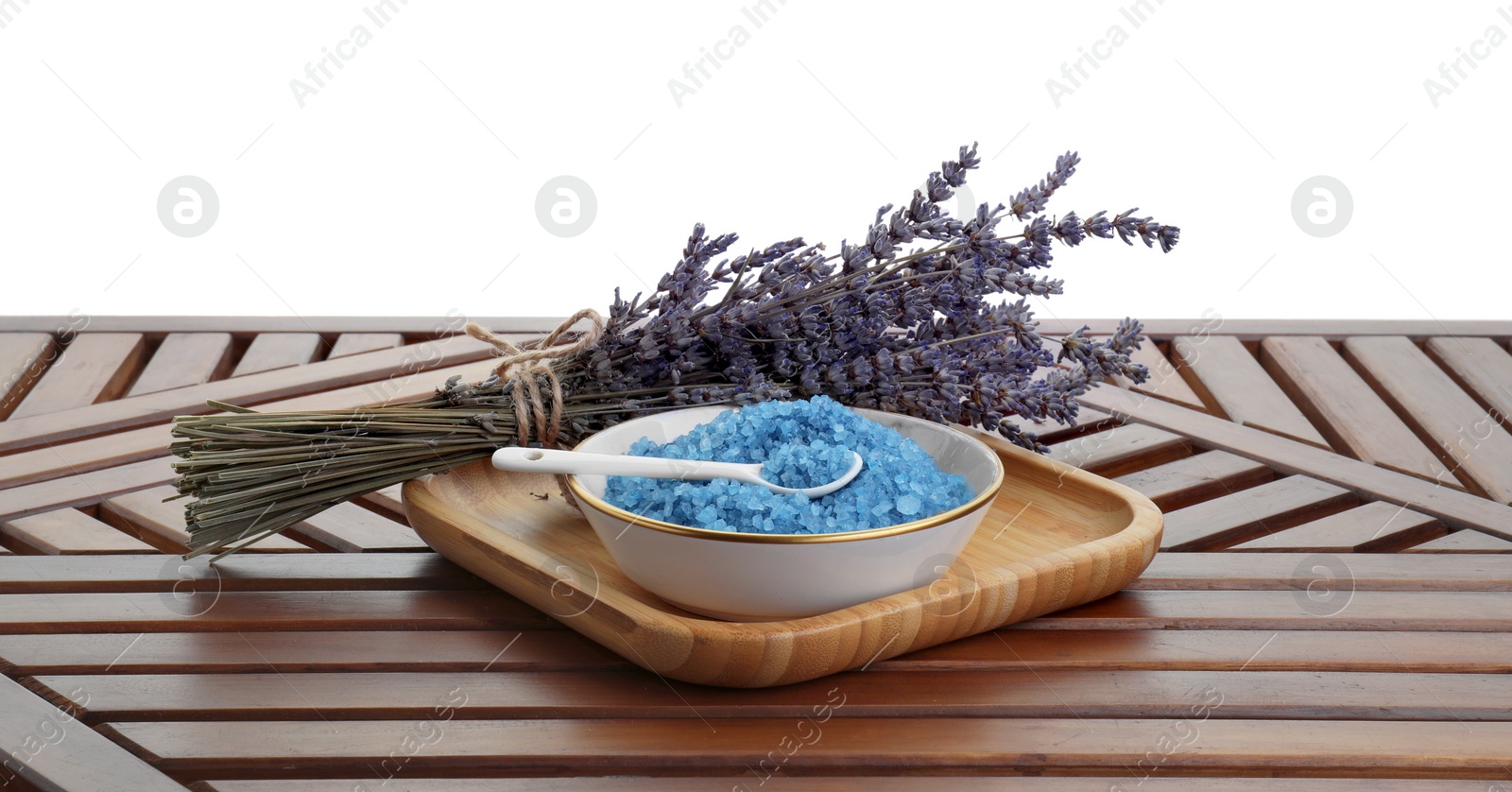 Photo of Bowl with blue sea salt and lavender flowers on wooden table against white background