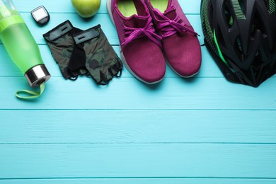 Photo of Flat lay composition with different cycling accessories on turquoise wooden background, space for text