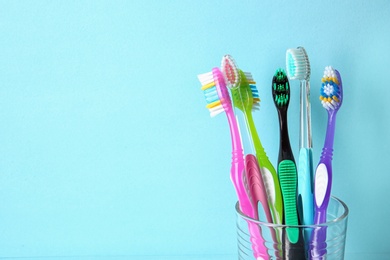 Photo of Cup with toothbrushes against color background. Dental care