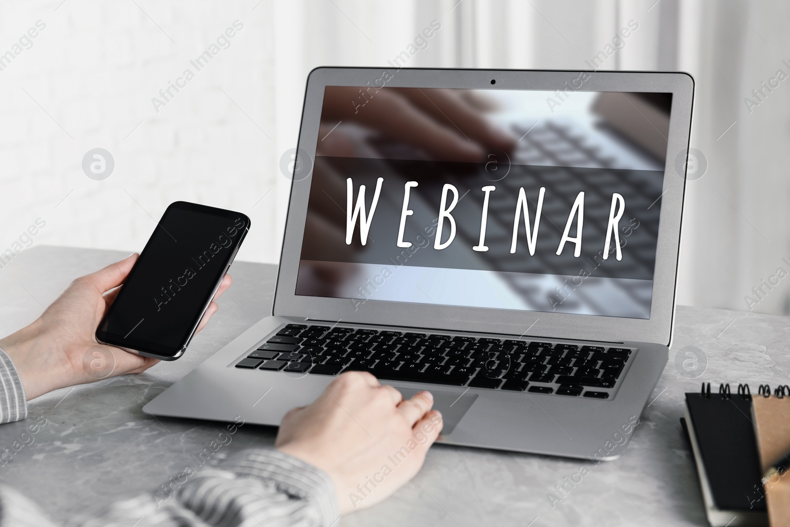 Image of Woman using laptop and smartphone at desk in office, closeup. Business webinar