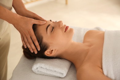 Photo of Young woman receiving head massage in spa salon