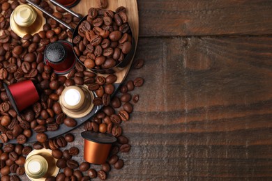 Saucepan with coffee capsules and beans on wooden table, flat lay. Space for text