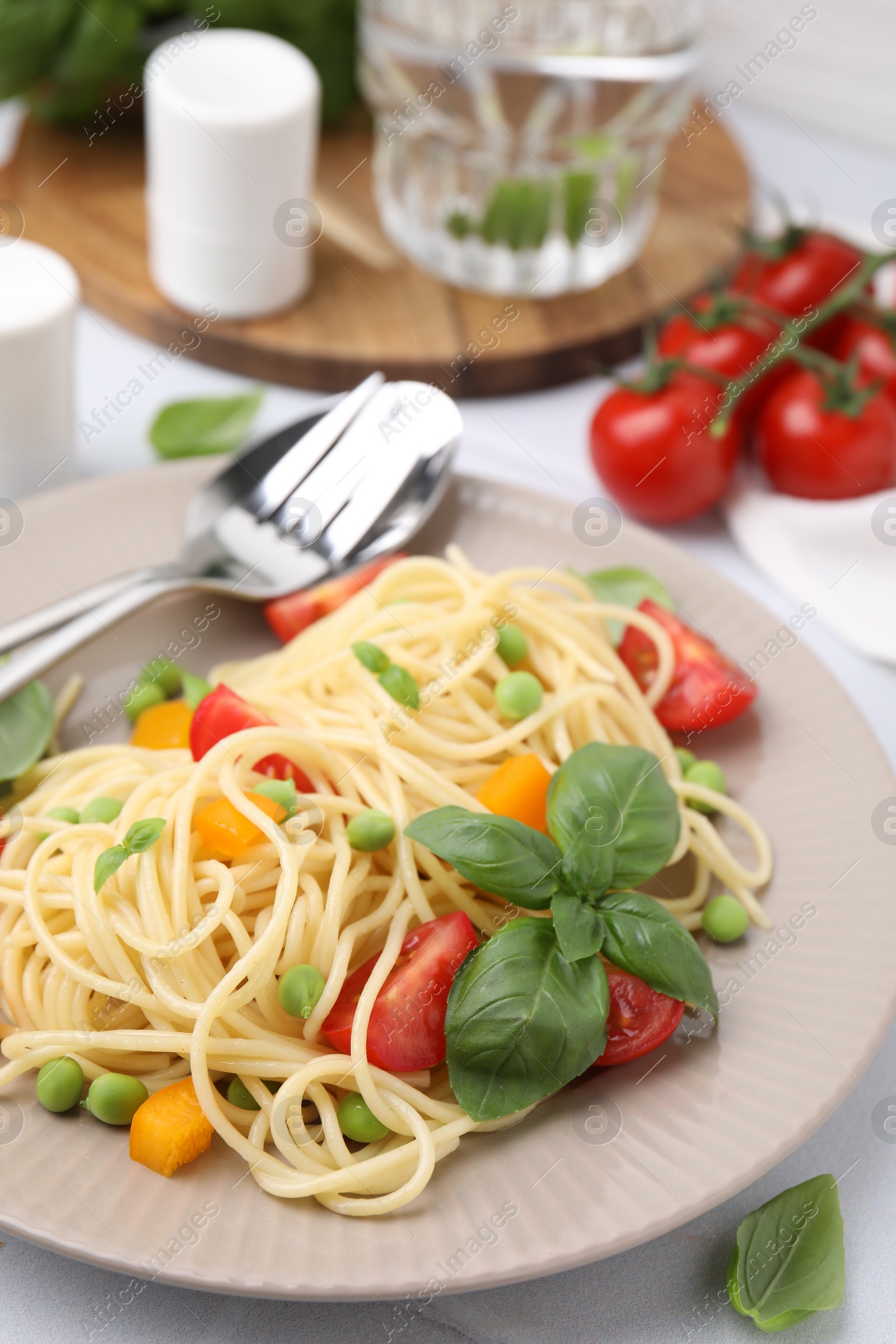 Photo of Plate of delicious pasta primavera served on white table, closeup