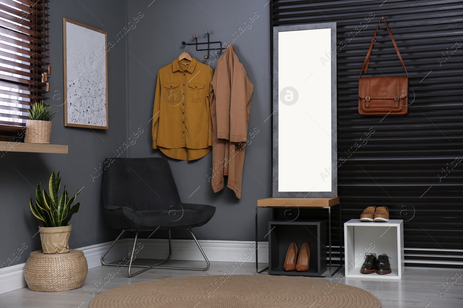 Photo of Hallway interior with modern furniture, mirror and hanging clothes