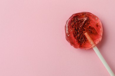 Photo of Sweet colorful lollipop with berries on pink background, top view. Space for text