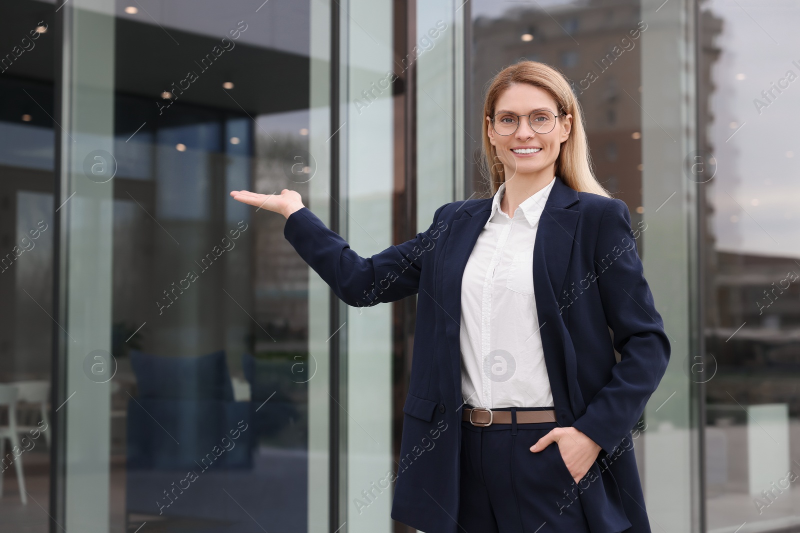 Photo of Happy real estate agent in suit outdoors