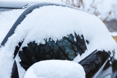 Modern car covered with snow outdoors on winter day, closeup. Frosty weather