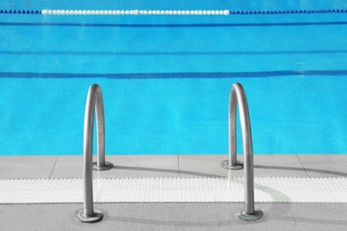 Photo of Ladder with handrails in outdoor swimming pool