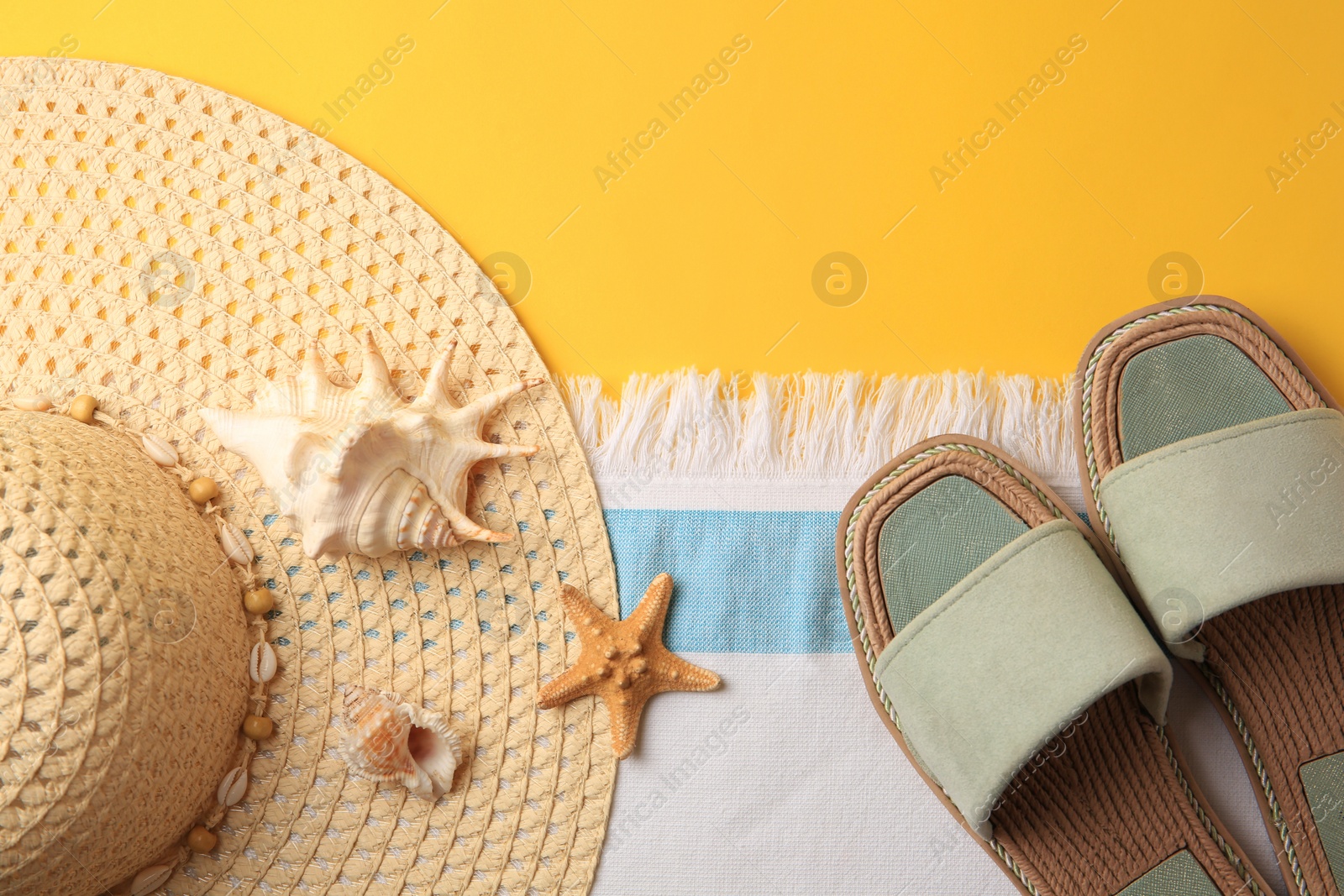 Photo of Flat lay composition with beach accessories on yellow background, space for text