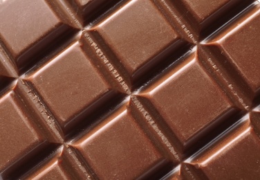 Photo of Tasty milk chocolate bar as background, top view