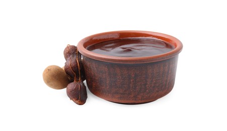 Photo of Bowl of tamarind sauce and fresh pods isolated on white