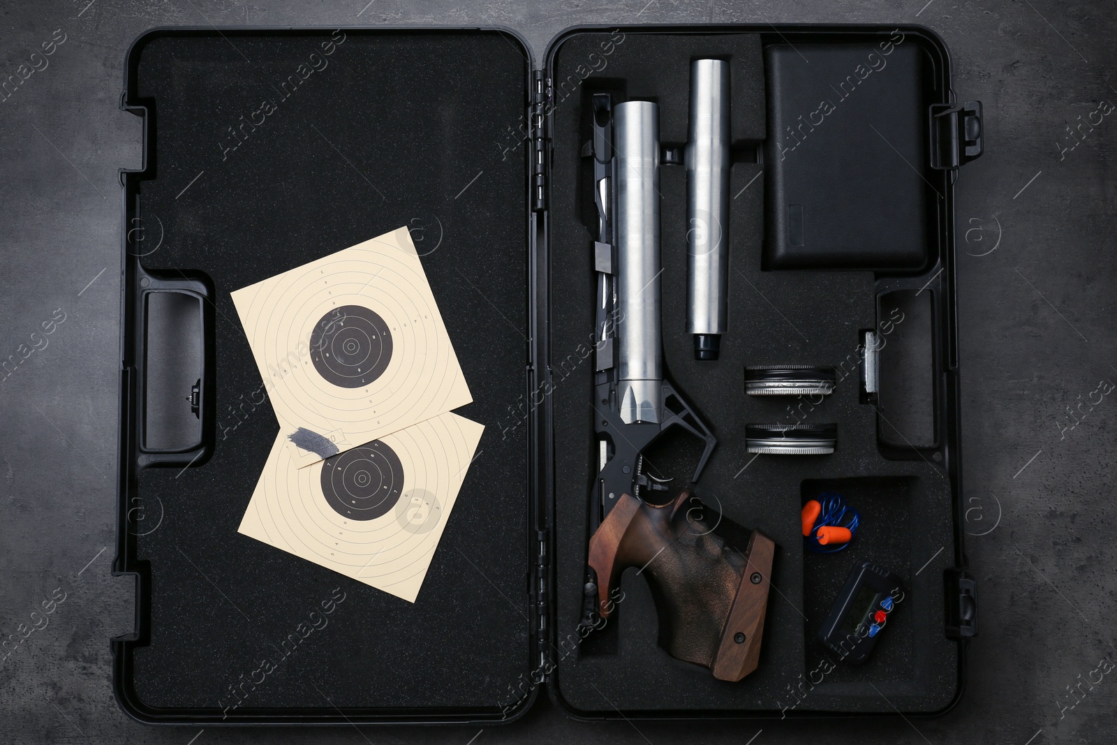 Photo of Case with sport pistol and accessories on black table, top view. Professional gun