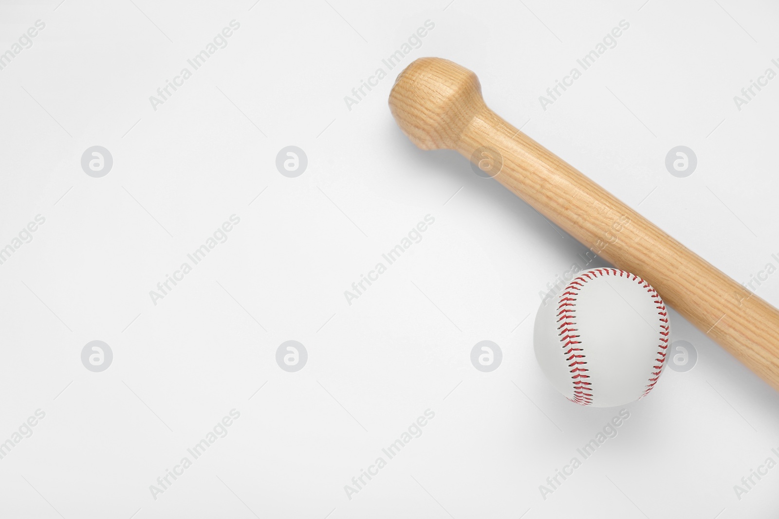 Photo of Wooden baseball bat and ball on white background, top view with space for text. Sports equipment