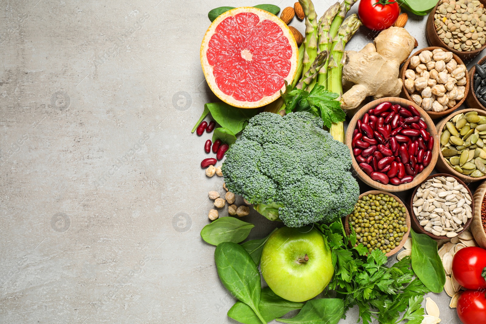 Photo of Flat lay composition with different vegetables, seeds and fruits on grey table, space for text. Healthy diet