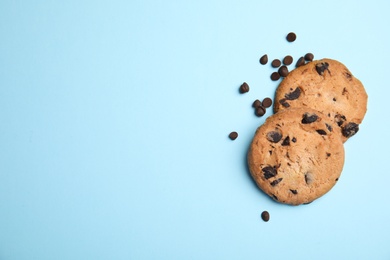 Photo of Delicious chocolate chip cookies on color background, flat lay. Space for text