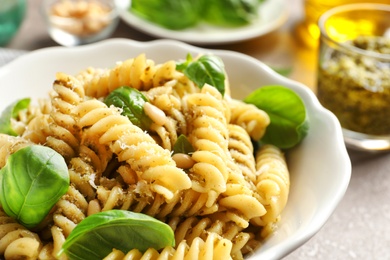 Photo of Plate of delicious basil pesto pasta on table, closeup