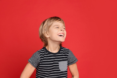 Portrait of happy little boy on red background