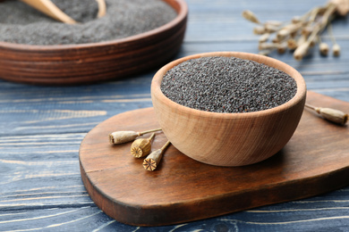 Photo of Poppy seeds in bowl on blue wooden table