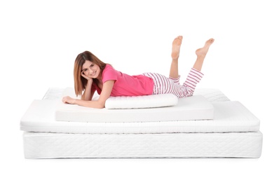 Woman lying on mattress pile against white background