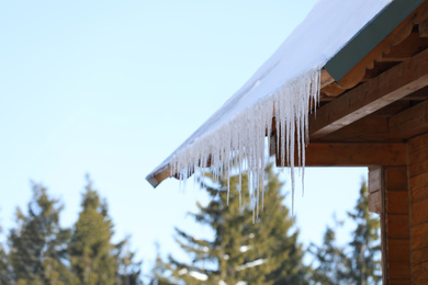 House with icicles on roof. Winter season