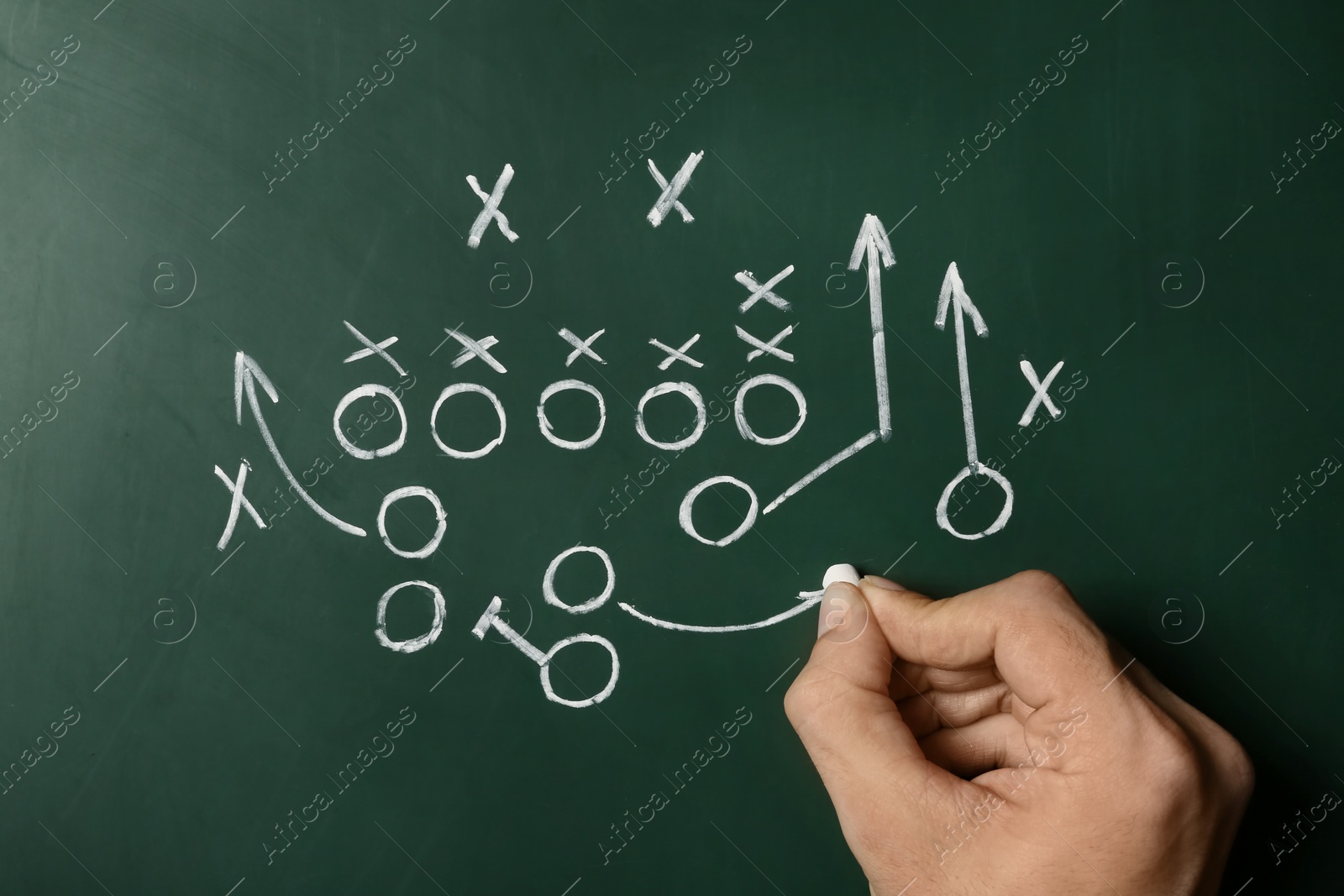 Photo of Man drawing football game scheme on chalkboard, top view