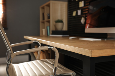 Photo of Comfortable workplace with table and office chair, closeup