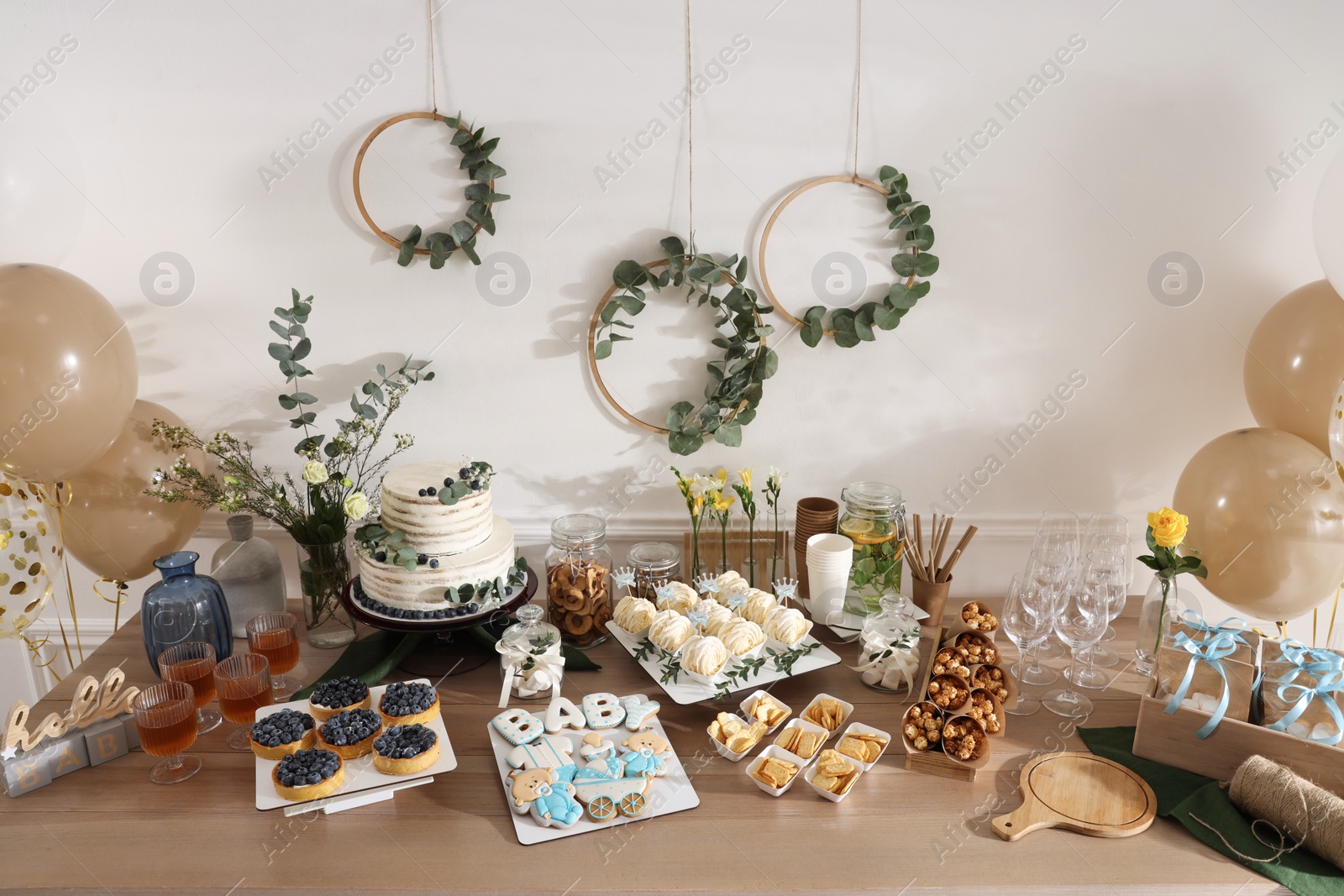 Photo of Beautiful cake and other treats on table in room. Baby shower party