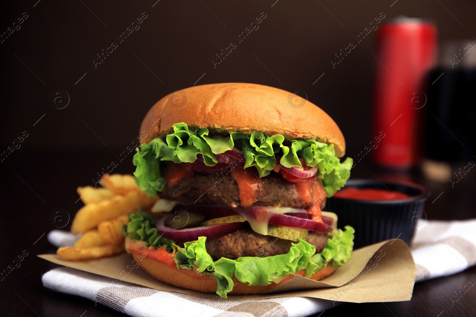 Photo of Tasty burger with vegetables, patties and lettuce served on wooden table, closeup