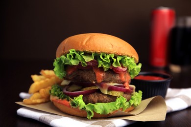 Tasty burger with vegetables, patties and lettuce served on wooden table, closeup